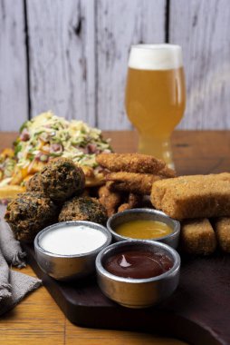 Masa ve tabakta Tequeo Gıda börekleri ve soslu nugget ve açık büfe yemekleri için patates ve peynir. 