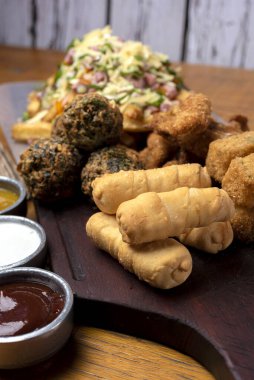 Masa ve tabakta Tequeo Gıda börekleri ve soslu nugget ve açık büfe yemekleri için patates ve peynir. 