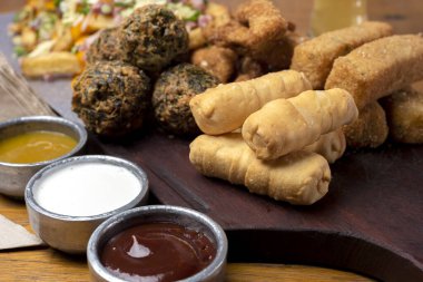 Masa ve tabakta Tequeo Gıda börekleri ve soslu nugget ve açık büfe yemekleri için patates ve peynir. 