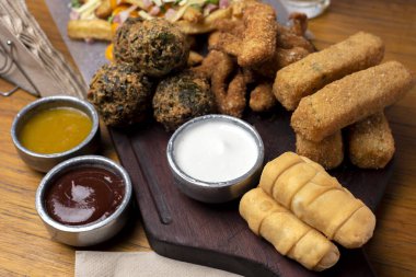 Masa ve tabakta Tequeo Gıda börekleri ve soslu nugget ve açık büfe yemekleri için patates ve peynir. 