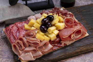 Çeşit çeşit peynirler, peynir formları, sosisler, dilimlenmiş fındıklar mavi rokfor parmesan jambonu ve sosis yemeye hazır. 