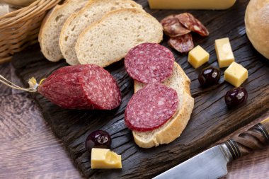 Çeşit çeşit peynirler, peynir formları, sosisler, dilimlenmiş fındıklar mavi rokfor parmesan jambonu ve sosis yemeye hazır. 