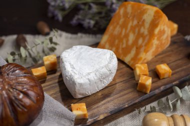 Çeşit çeşit peynirler, peynir formları, sosisler, dilimlenmiş fındıklar mavi rokfor parmesan jambonu ve sosis yemeye hazır. 