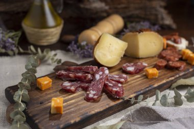 Çeşitli peynirler ve sosisler ve doğranmış fındıklar. Salam, sosis, rokfor, parmesan jambon ve sosis yemeye hazır. Hayat fotoğrafı. 