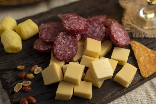 table of various cheeses and sausages and cut and chopped nuts ready to eat salami sausage blue cheese roquefort parmesan jammon and sausages still life photo