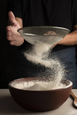 Kadın ve kızın elleri fırıncılar hamur yoğurur ve unlu yumurtalarla birleştirirler. Süt balı bir tarif yapar adım adım hamur yapar. 