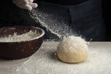 Kadın ve kızın elleri fırıncılar hamur yoğurur ve unlu yumurtalarla birleştirirler. Süt balı bir tarif yapar adım adım hamur yapar. 