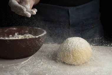 Kadın ve kızın elleri fırıncılar hamur yoğurur ve unlu yumurtalarla birleştirirler. Süt balı bir tarif yapar adım adım hamur yapar. 