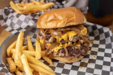 Ev yapımı taze et burgerler, patates ekmeği, yumurta pastırması, domates, soğan, çedar peyniri, jambon, farklı çeşitlerde patates kızartması ve fast food sosu. 