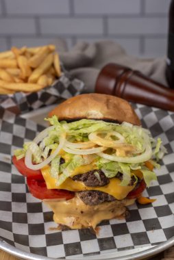 Ev yapımı taze et burgerler, patates ekmeği, yumurta pastırması, domates, soğan, çedar peyniri, jambon, farklı çeşitlerde patates kızartması ve fast food sosu. 