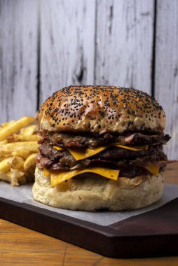 Ev yapımı taze et burgerler, patates ekmeği, yumurta pastırması, domates, soğan, çedar peyniri, jambon, farklı çeşitlerde patates kızartması ve fast food sosu. 