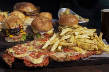 Ev yapımı taze et burgerler, patates ekmeği, yumurta pastırması, domates, soğan, çedar peyniri, jambon, farklı çeşitlerde patates kızartması ve fast food sosu. 