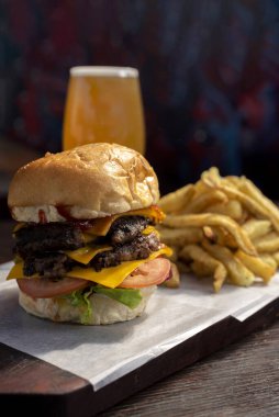 Ev yapımı taze et burgerler, patates ekmeği, yumurta pastırması, domates, soğan, çedar peyniri, jambon, farklı çeşitlerde patates kızartması ve fast food sosu. 