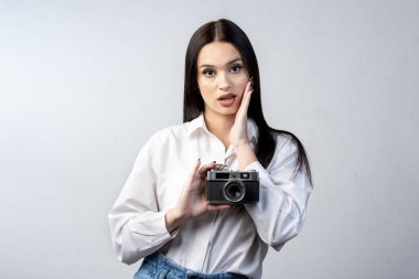 Elinde fotoğraf makinesi olan genç Latin bir kadın gülümsüyor ve yaşam tarzını fotoğraflıyor. 