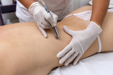 Güzellik ve güzellik merkezinde genç bir kadın. Elmas uçlu bir teknikle vücut ve cilt bakımı için güzellik tedavisi uyguluyor. 