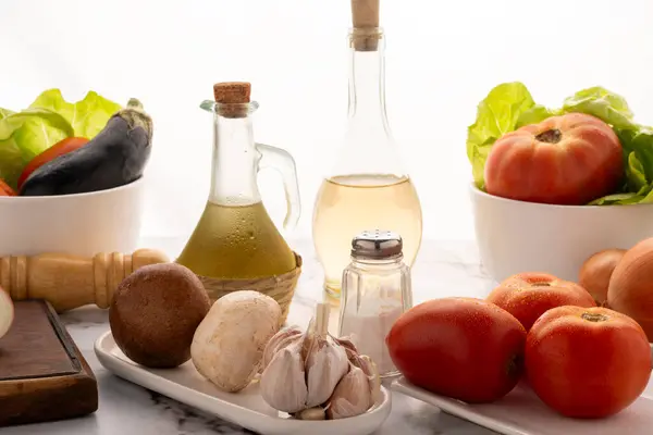 Salata, vejetaryen ve vejetaryen yemekleri için biber sirkesi ve tuzlu beyaz sofra takımında çeşitli sebzelerle masaya koyun. 
