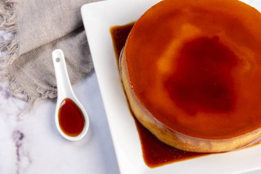 Ev yapımı flan ya da Venezuela peyniri. Karamelli ve bireysel ya da büyük porsiyonlu beyaz sofra takımı. 