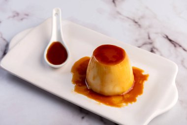 Ev yapımı flan ya da Venezuela peyniri. Karamelli ve bireysel ya da büyük porsiyonlu beyaz sofra takımı. 