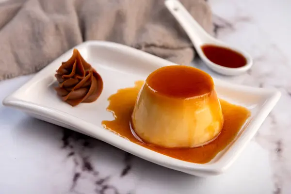 Ev yapımı flan ya da Venezuela peyniri. Karamelli ve bireysel ya da büyük porsiyonlu beyaz sofra takımı. 