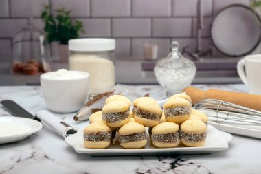 Ev yapımı mısır nişastası, yanında dulce de leche ve hindistan cevizi rendelenmiş Hindistan cevizi, içinde de un şekeri çırpılmış.