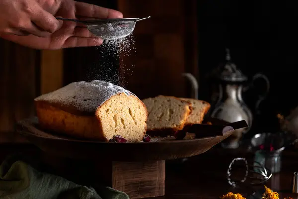 Vanilyalı puding ya da ahşap üzerine antika çay seti ve aperatif ya da kahvaltı için şeker serpiştiren eller. 