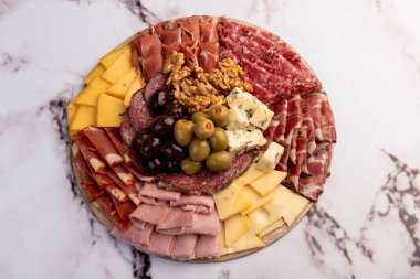 Çeşit çeşit peynirle servis edilen servis masası, sardunya peyniri ve kekik ve zeytin aromalı ev yapımı ekmek fileto, jambon, domuz omuzu, salam, fındıklı mortadella ve çeşitli sosisli sandviçler. 