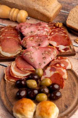 Çeşit çeşit peynirle servis edilen servis masası, sardunya peyniri ve kekik ve zeytin aromalı ev yapımı ekmek fileto, jambon, domuz omuzu, salam, fındıklı mortadella ve çeşitli sosisli sandviçler. 
