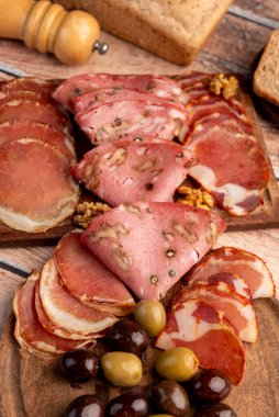 Çeşit çeşit peynirle servis edilen servis masası, sardunya peyniri ve kekik ve zeytin aromalı ev yapımı ekmek fileto, jambon, domuz omuzu, salam, fındıklı mortadella ve çeşitli sosisli sandviçler. 