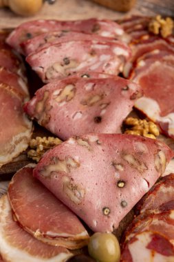 Çeşit çeşit peynirle servis edilen servis masası, sardunya peyniri ve kekik ve zeytin aromalı ev yapımı ekmek fileto, jambon, domuz omuzu, salam, fındıklı mortadella ve çeşitli sosisli sandviçler. 