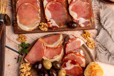 Çeşit çeşit peynirle servis edilen servis masası, sardunya peyniri ve kekik ve zeytin aromalı ev yapımı ekmek fileto, jambon, domuz omuzu, salam, fındıklı mortadella ve çeşitli sosisli sandviçler. 