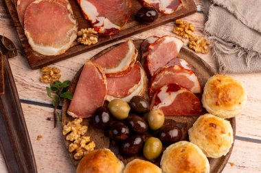 Çeşit çeşit peynirle servis edilen servis masası, sardunya peyniri ve kekik ve zeytin aromalı ev yapımı ekmek fileto, jambon, domuz omuzu, salam, fındıklı mortadella ve çeşitli sosisli sandviçler. 