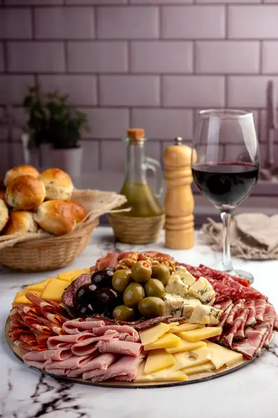 Çeşit çeşit peynirle servis edilen servis masası, sardunya peyniri ve kekik ve zeytin aromalı ev yapımı ekmek fileto, jambon, domuz omuzu, salam, fındıklı mortadella ve çeşitli sosisli sandviçler. 