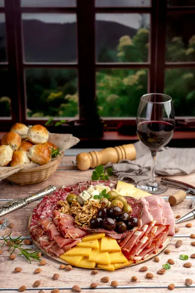 Çeşit çeşit peynirle servis edilen servis masası, sardunya peyniri ve kekik ve zeytin aromalı ev yapımı ekmek fileto, jambon, domuz omuzu, salam, fındıklı mortadella ve çeşitli sosisli sandviçler. 