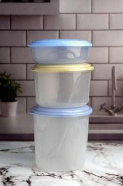 Mutfak tezgahında çok amaçlı plastik yiyecek kapları, sebzeler, etler, peynirler. 