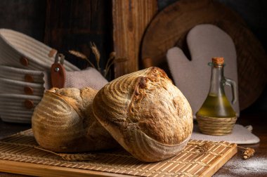 Sağlıklı, organik, bütün ve dilimlenmiş ev yapımı ekmek, ahşap bir masa üzerinde jambon ve peynir ve kabuklu mutfak gereçleri.. 