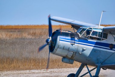 Mavi gökyüzünün arka planında beyaz bulutlu eski bir uçak.