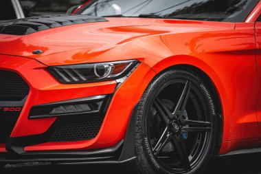 Kırmızı ve beyaz araba, bir sürü farları ve farları var.