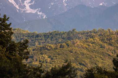 Dağları ve mavi gökyüzü olan güzel bir manzara.