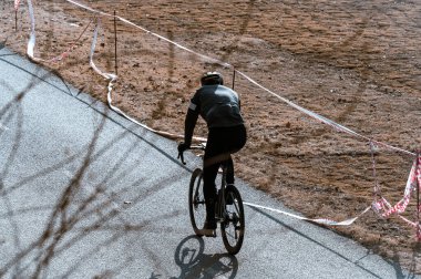 Bisikletçi yolda bisiklet sürüyor.