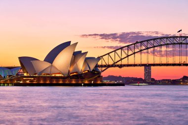 Sydney mi? Yeni Güney Galler. Avustralya. Gün batımında Opera Binası ve liman köprüsü - Tarih: 23 - 08 - 2023