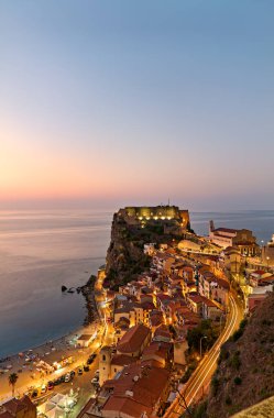 The city of Scilla Calabria Italy. Elevated view of the illuminated Ruffo castle at sunset - Date: 26 - 08 - 2023 clipart
