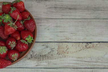 Tahta masadaki taze çilekler.