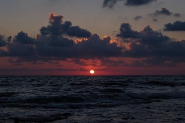 Denizin üzerinde gün batımı. Güneşin bulutları.