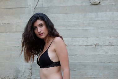 Siyah sutyenle poz veren genç kız.