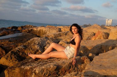 Rocky Sahili 'nde siyah elbiseli güzel esmer manken.