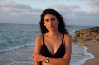 Güzel kıvırcık saçlı ve beyaz elbiseli genç bir kız.