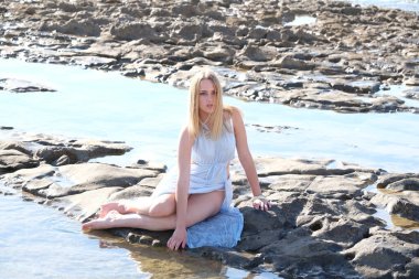 Denizde kayalıklarda genç bir kız