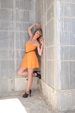 Beyaz arka planda turuncu elbiseli güzel bir kadın.