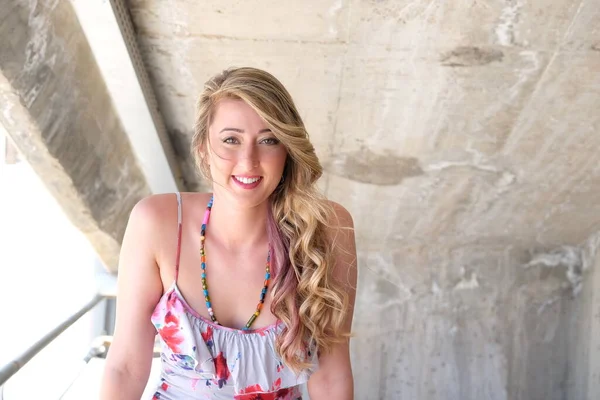 Kumsalda mavi elbiseli genç sarışın kadın.