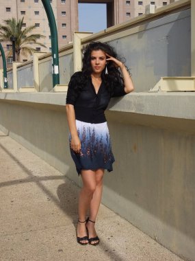 Göz kamaştırıcı bir İspanyol kadın modeli çevrede yürürken poz veriyor.